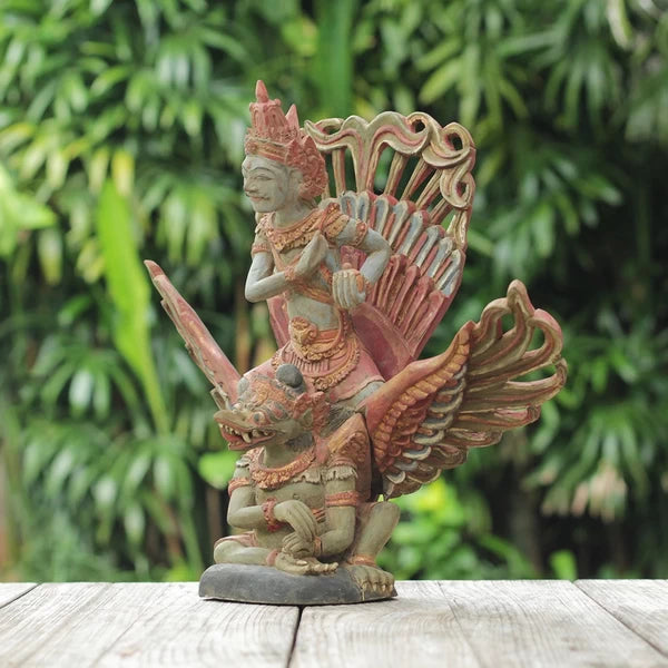 Cette sculpture en bois de teck, sculptée à la main à Bali, représente le puissant Garuda portant Vishnu. Un chef-d'œuvre qui apportera une touche d'exotisme et de spiritualité à votre intérieur.