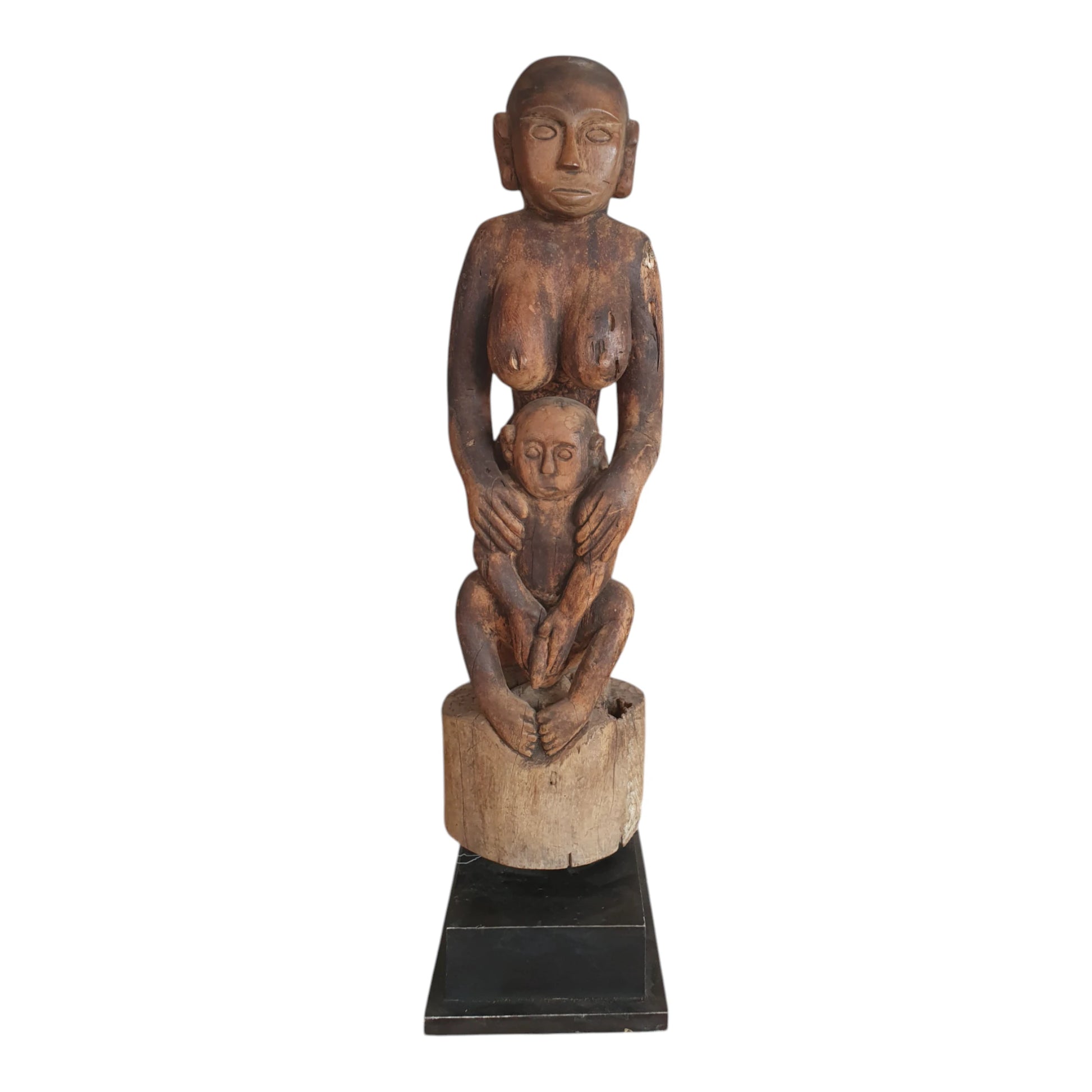 Statue de maternité en bois sculpté du Timor, représentant une femme tenant un enfant entre ses bras, sur socle noir – H75 cm.