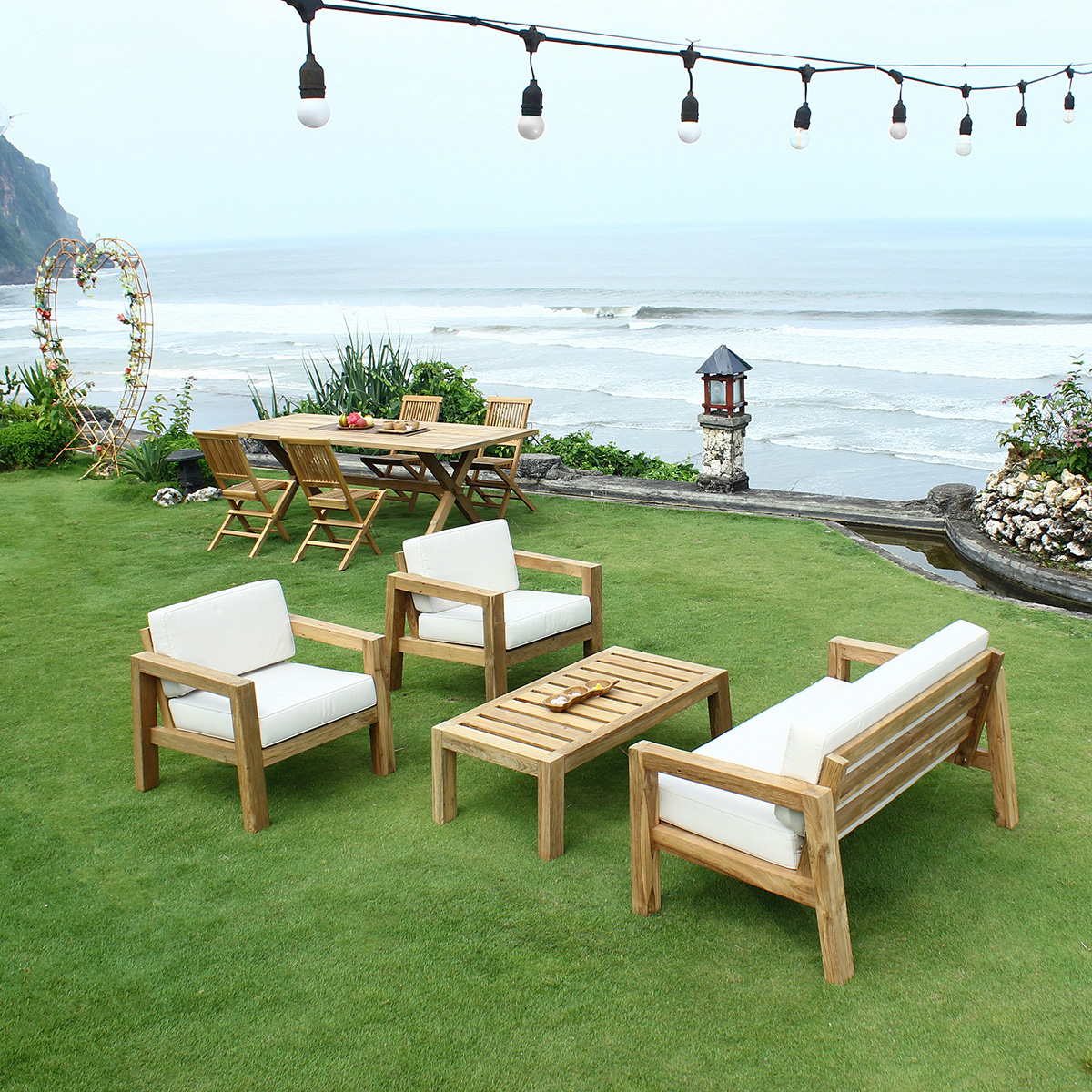 Salon de jardin lounge en teck avec deux fauteuils, un sofa et une table basse, le meuble teck indispensable pour passer de belles soirées d'été sur la terrasse !